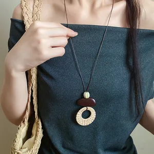 Bohemian style long necklace with hand-woven circular pendant worn by a model