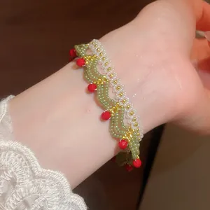 Detailed macro view of an elegant handmade green and red beaded flower lace bracelet