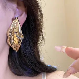 Detailed close-up showing texture of vintage gold lip-shaped earring with rhinestones