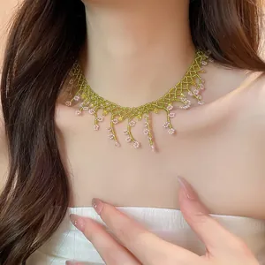 Close-up of handmade green and pink beaded choker with delicate floral lace patterns.
