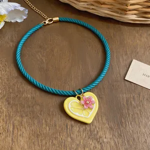 Close-up of vibrant dopamine style necklace with lemon heart pendant and pink flower