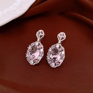 Detailansicht von Vintage-Ohrringen mit rosa ovalem Zirkon auf braunem Stoff