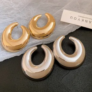 Dettaglio di orecchini a perno ovali cavi in metallo vintage in oro e argento lucido