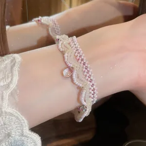 Close-up of handmade pink beaded bracelet with elegant glass drop pendant