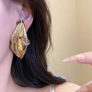 Detailed view of vintage gold lip-shaped earring with sparkling rhinestones worn on ear