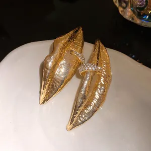 Close-up detail of vintage lip-shaped golden earrings with sparkling crystal accents