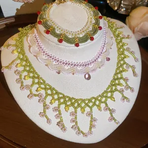 Close-up of handmade beaded jewelry set featuring green lace necklace and bracelet