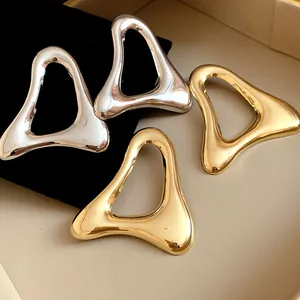 Primo piano di orecchini a lobo vintage a triangolo cavo in finitura argento e oro