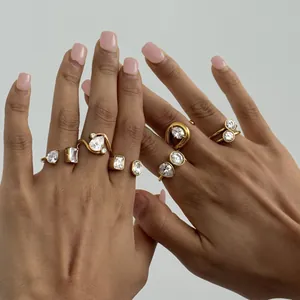 Detailed view of multiple gold-plated stainless steel rings set with clear zircon stones