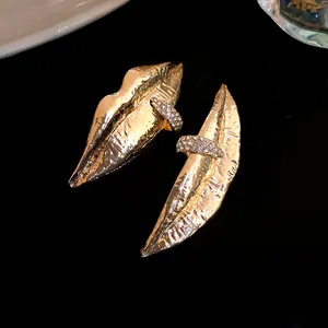Detailed macro view of vintage gold textured lip earrings with pavé rhinestones