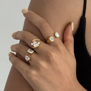 Close-up detail of gold-plated stainless steel rings featuring clear zircon stones.