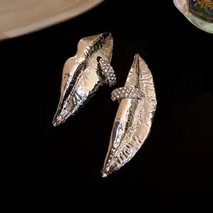 Detailed macro shot of vintage silver-tone lip-shaped earrings with rhinestone accents.