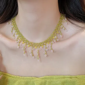 Close-up detail of an elegant handmade green and pink beaded floral fringe necklace