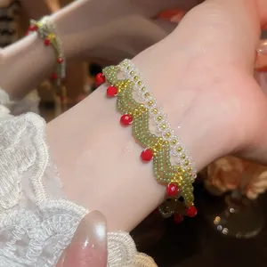 Close-up detail of handmade green and white glass beaded lace bracelet on elegant wrist.