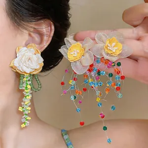 Detail view of Korean style fabric flower earrings with long colorful glass beaded tassels