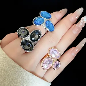 Vintage silver and gold open rings with three oval crystals in blue, black, and pink.