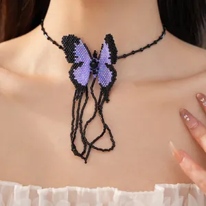Nahaufnahme eines handgefertigten Halsbands mit lila Perlen-Schmetterling.