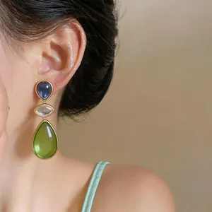 Detailed close-up of elegant three-tier resin water drop earrings in green and blue
