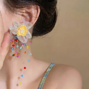 Detail of Korean fabric flower earrings with colorful glass bead tassels.