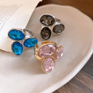 Detailed view of three vintage oval gemstone rings in pink, blue, and grey