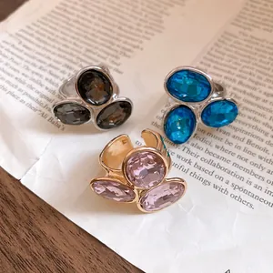 Detailed view of vintage oval rhinestone open rings in pink, blue, and black jewelry.