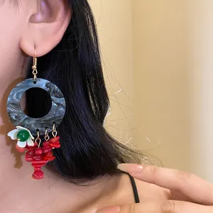 Detailed close-up of Neo-Chinese style drop earrings featuring red stones and white flower