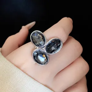 Close-up of vintage silver-tone open ring with three oval dark grey stones