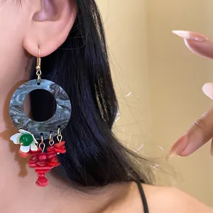 Detailed view of New Chinese style earrings with marbled hoops and red dangles
