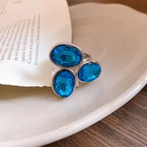 Detailed view of a vintage silver open ring featuring three sparkling blue oval crystals