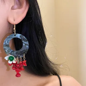 Detail view of New Chinese style floral hoop earrings with elegant red and green stone accents.