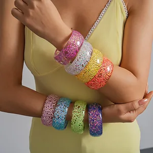 Detailed view of multiple colorful resin bangles with iridescent heart glitter inserts