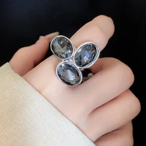 Detailed macro view of a vintage silver open ring featuring three oval grey crystal stones.