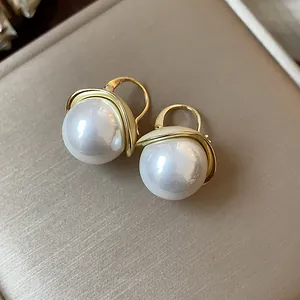 Detailed view of French style elegant round pearl lever-back earrings in gold finish