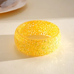 Detailed macro view of yellow resin bangle showing faceted dopamine style texture