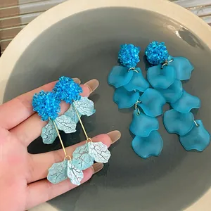Close-up detail of blue hydrangea tassel earrings with frosted petals and beadwork