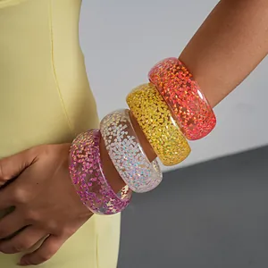 Detailed macro view of vibrant iridescent resin bangles featuring colorful geometric sparkles