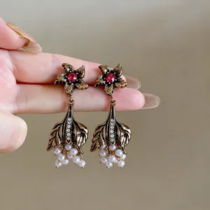 Close-up detail of vintage court style earrings featuring red rhinestones and white pearls