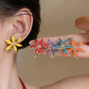 Eleganti orecchini a lobo a fiore in smalto multicolore con strass mostrati sul modello