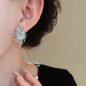 Detailaufnahme eines silbernen Sternschliff-Ohrrings mit glitzernden Strasssteinen am Ohr getragen