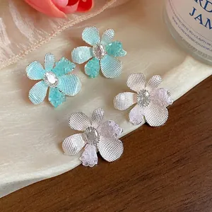 Elegant zircon glass flower stud earrings in teal and pink on silk fabric