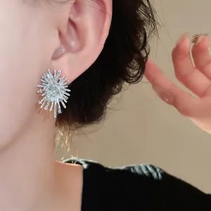 Detaillierte Makroansicht eines silbernen Stern-Ohrsteckers mit Kristallen am Ohr