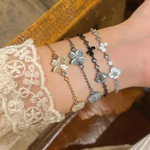 Close-up of delicate flower and butterfly bracelets with cat eye stones on a wrist.