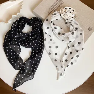 Macro view of vintage polka dot chiffon scarves with flower accents on jewelry box