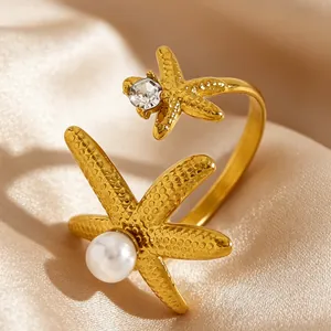 Gros plan d'une bague étoile de mer dorée avec perle et zircon étincelant