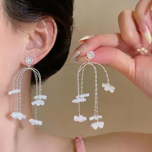 Elegante lange Gänseblümchen-Quastenohrringe mit weißen Harzblumen für den Urlaub.