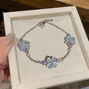 Elegant detail of a silver zircon and cat eye stone flower bracelet in a beige jewelry box