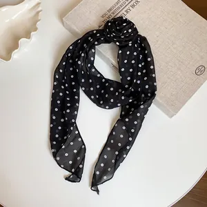 Close-up view of a retro black polka dot chiffon scarf featuring an elegant handmade fabric flower