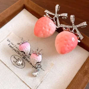 Detailed view of sweet pink strawberry earrings with sparkling cubic zirconia stones.