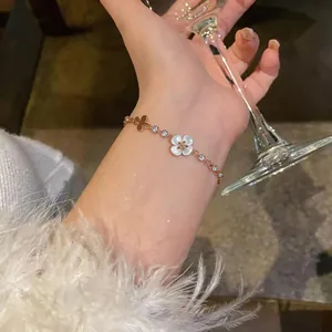 Elegant rose gold flower and butterfly charm bracelet with white cat-eye clover and zircons
