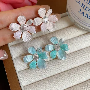 Detailed close-up of elegant floral stud earrings featuring sparkling zircon centers